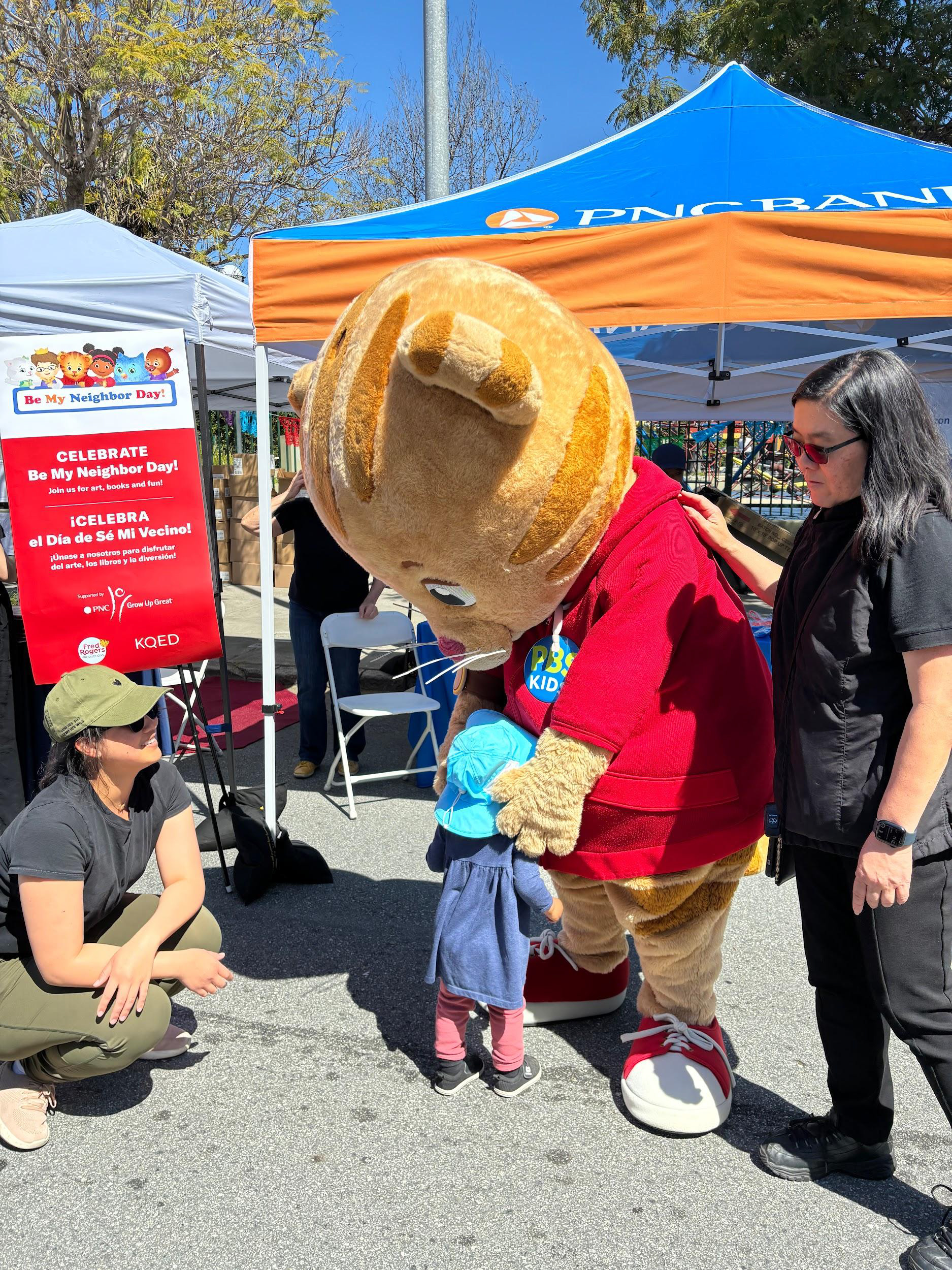 Daniel Tiger hugging a child