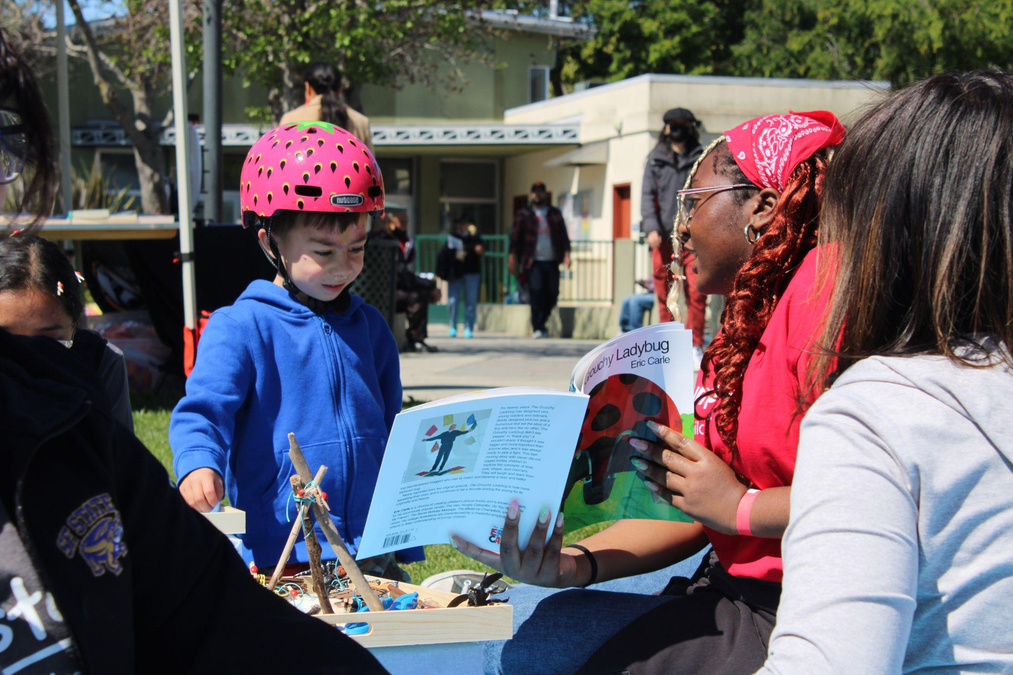 A Jumpstart mentee reading a book to a boy