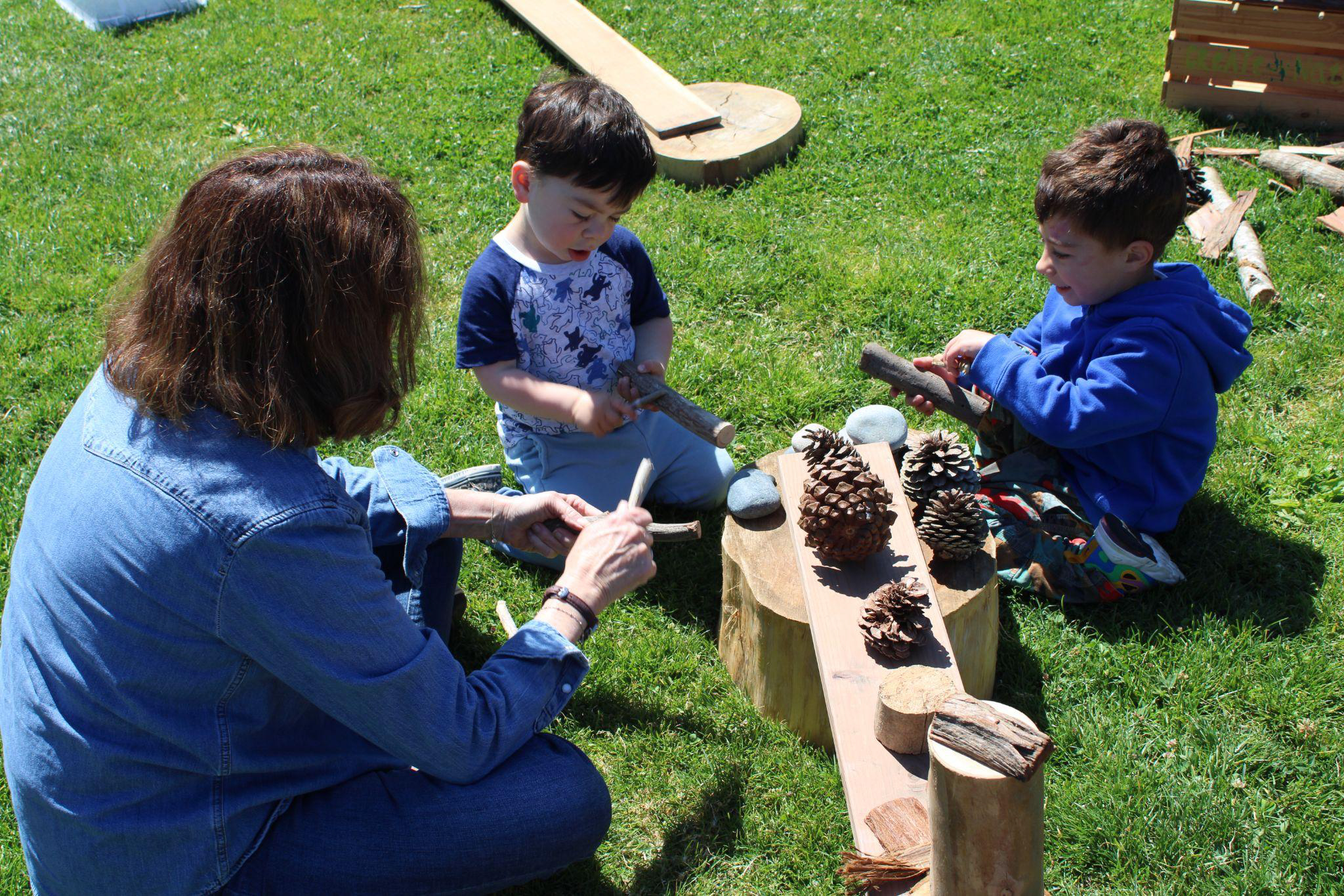 Two boys and their mother playing with pinecones