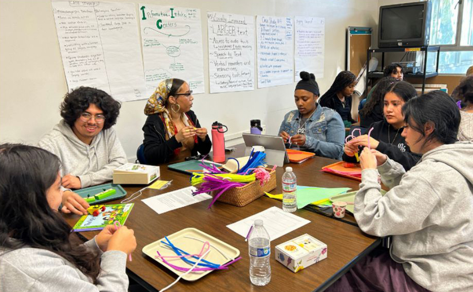 Students around a table making crafts