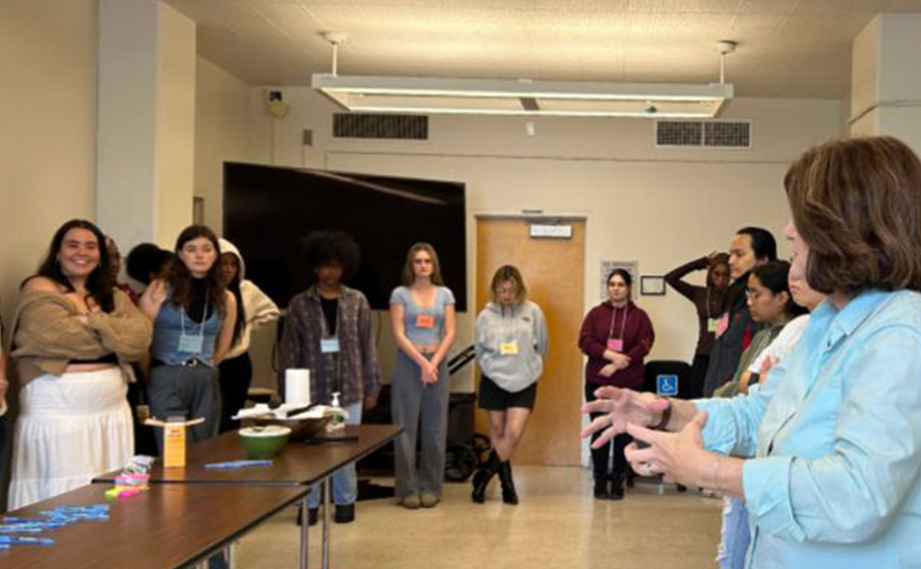 Students standing in a circle, listening